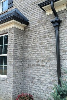 a red fire hydrant sitting in front of a brick building next to a window