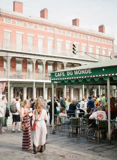 a group of people standing in front of a cafe