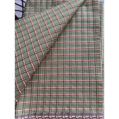 the green and pink plaid fabric is folded on top of a metal rack with wire