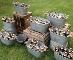 a bunch of buckets that are sitting in the grass next to some beer bottles