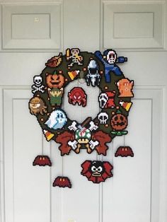 a cross stitch wreath with video game characters hanging from it's front door frame