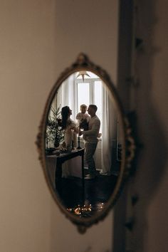 a man and woman standing in front of a mirror