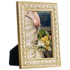 a woman's hand holding a bouquet of flowers in a gold frame