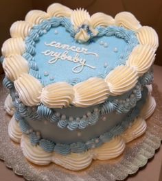 a blue and white heart shaped cake sitting on top of a table