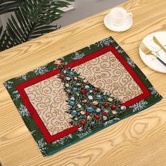 a placemat with a christmas tree on it next to a plate and fork,