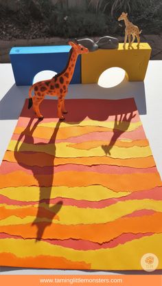 a giraffe standing on top of a colorful rug