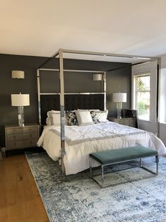 a bedroom with a four poster bed and blue rug