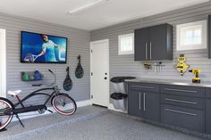 a bike is parked in front of a flat screen tv mounted on the kitchen wall