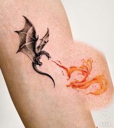 a dragon and fire breathing tattoo on the right side of the leg, it appears to be black