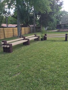 several wooden benches in the middle of a grassy area