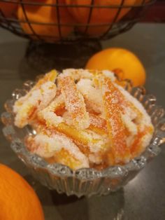 a bowl filled with oranges and powdered sugar on top of a table next to an orange