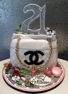 a chanel bag cake is decorated with flowers, pearls and glitters for the 21st birthday girl