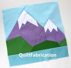 a piece of paper with mountains on it and the words quiltfabrication written in white