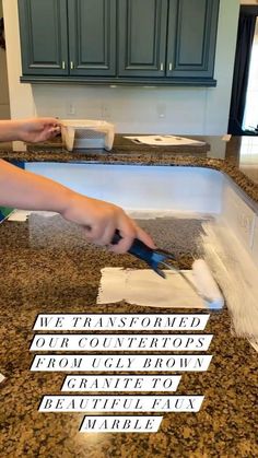 a person cutting up some paper on top of a kitchen counter with scissors and tape