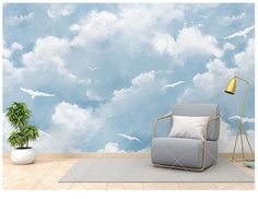 a living room with a chair, lamp and wallpaper that has clouds on it