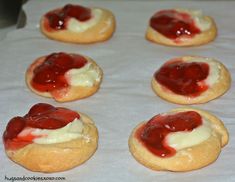 small cookies with cream and jelly on them are ready to be baked in the oven