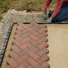 a man is laying bricks on the ground