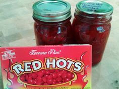 two jars of red hots sitting on top of a table