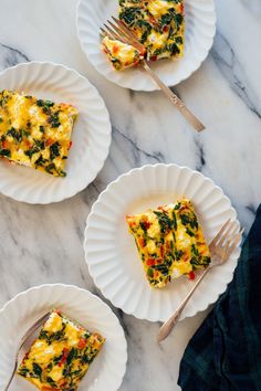 three plates with slices of quiche on them, one has cheese and the other has spinach