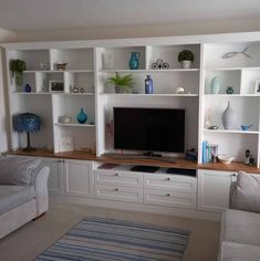 a living room with two couches and a flat screen tv on a wall unit