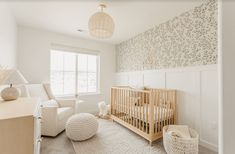 a baby's room with a crib, rocking chair and large window