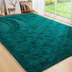 a large green rug on the floor in front of a sliding glass door with an open window