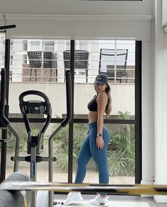 a woman standing in front of a gym machine