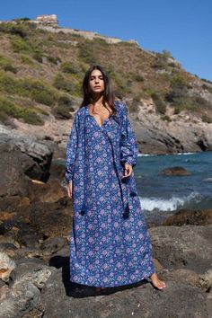 The Bella kaftan is made of light cotton silk voile and printed with vibrant florals. It has a lightweight, airy silhouette with long sleeves, button closure, and a tassel detail. This bohemian kaftan is the epitome of boho-chic style and is as elegant as it is comfortable. Bohemian Long Sleeve Boho Dress With Floral Print, Long Sleeve Bohemian Boho Dress With Floral Print, Long Sleeve Bohemian Dress With Floral Print, Long Sleeve Boho Dress For Beach, Bohemian Maxi Kaftan With Floral Print, Long Sleeve Boho Beach Dress With Tassels, Long Sleeve Floral Print Dress For Beachwear, Long Sleeve Boho Beach Cover-up Dress, Long Sleeve Tassel Dress For Beach