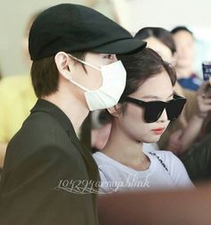 a man and woman wearing face masks at an airport