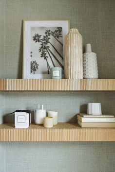 two wooden shelves with candles and pictures on them