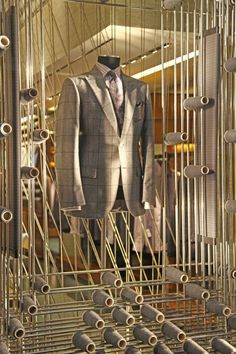 a suit and tie are on display in a room with lots of metal rods,