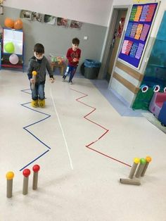 two young boys playing with toys in a play room