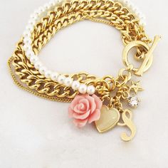 "layered personalized pearl gold bracelet with dangling charms. This romantic bracelet features charms and one row of pearls and three rows of curb chain This bracket is a T form that one end enters the round ring for closing, very easy for self-wearing. It comes with 4 charms: a heart, a flower, a small zircon, and a star, The bracelet also comes with a letter of your choice (Please advise which letter while placing the order) The bracelet is made of high-quality NICKEL FREE coating. If you are Pearl Gold Bracelet, Romantic Bracelet, Initial Charm Bracelet, Gold Pearl Bracelet, Layered Bracelet, Bracelet Initial, Personalized Bridesmaid Gifts, Bridesmaid Bracelet, Bridesmaids Personalized