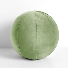 a green ball sitting on top of a white floor