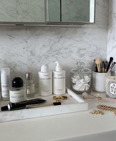 a bathroom counter topped with lots of personal care items