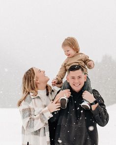 a man and woman holding a child in the snow