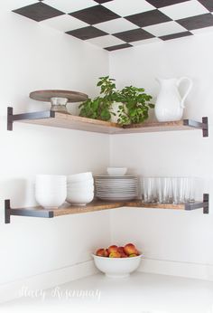 two open shelving shelves with bowls and plates on them in a white kitchen area