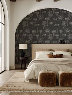 a large bed sitting in a bedroom next to a tall wall mounted clock with palm trees on it