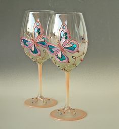 two wine glasses with butterflies painted on them