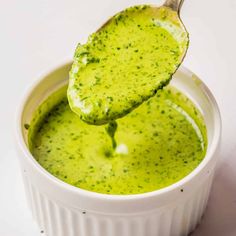 a spoon full of pesto sauce with a wooden spoon