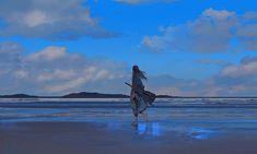 a woman is walking on the beach with her surfboard