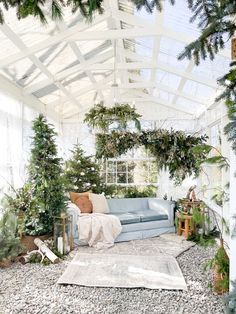 a living room filled with lots of greenery and furniture under a white awning