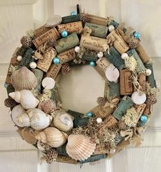 a wreath made out of wine corks and seashells is hanging on a door