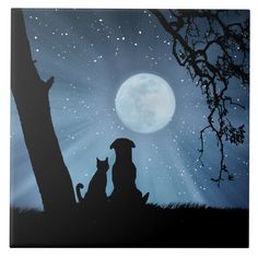 two dogs sitting under a tree with the moon in the background