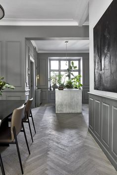 a dining room with grey walls and wooden floors