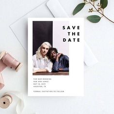 a photo save the date card on top of a white envelope next to a spool of thread