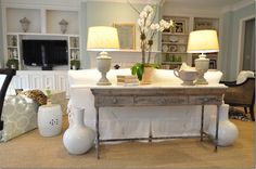 a living room filled with furniture and two lamps on top of each other's tables