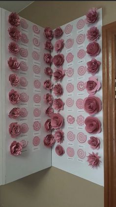 paper flowers are arranged on the inside of an open book that is decorated with pink circles and spirals