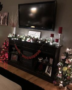 a living room decorated for christmas with lights and decorations on the fireplace mantels