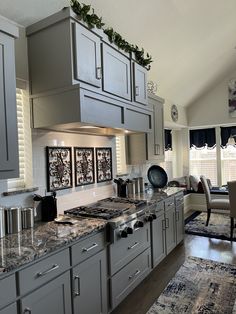 a kitchen with gray cabinets and marble counter tops